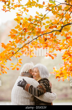Coppia di anziani abbracciando in posizione di parcheggio Foto Stock
