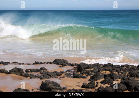 Maestose onde dell'Oceano Indiano la rottura sul bagnato a riva e la scure rocce basaltiche a Ocean Beach Bunbury . Foto Stock