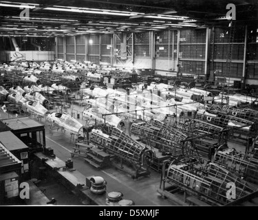 Questa immagine mostra il processo di assemblaggio della fusoliera per il Republic P-47D "Thunderbolt", un aereo da caccia della seconda guerra mondiale noto per il suo design robusto e il potente motore. Il P-47 fu utilizzato per la superiorità aerea, l'attacco al suolo e le missioni di scorta dei bombardieri, diventando uno dei caccia di maggior successo della guerra. Foto Stock