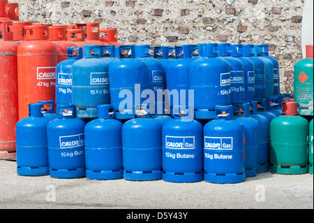 Pile di rosso verde e blu Calor Gas butano e propano cilindri Foto Stock