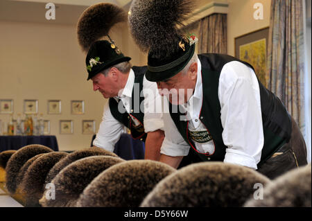 Membro della Giuria Hias Koch (L) e Herbert Eder esaminare parti di un cappello chiamato chamios barba durante la ventiseiesima Gamsbart Olimpiadi (lit. camosci barba olimpiadi) in Mittenwald, Germania, 14 ottobre 2012. Fino a 100 partecipanti provenienti da diverse aree Apline hanno partecipato all'evento. Foto: Frank Leonhardt Foto Stock