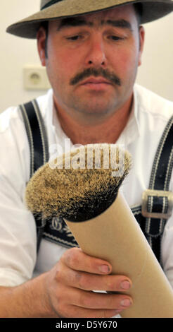 Un membro della giuria esamina una parte di un cappello chiamato chamios barba durante la ventiseiesima Gamsbart Olimpiadi (lit. camosci barba olimpiadi) in Mittenwald, Germania, 14 ottobre 2012. Fino a 100 partecipanti provenienti da diverse aree Apline hanno partecipato all'evento. Foto: Frank Leonhardt Foto Stock