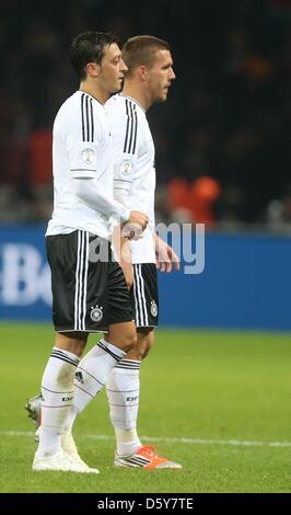 La Germania Mesut Oezil (L) e Lukas Podolski reagire dopo la Coppa del Mondo FIFA 2014 qualifica partita di calcio tra la Germania e la Svezia allo stadio Olimpico di Berlino, Germania, 16 ottobre 2012. Foto: Kay Nietfeld/dpa +++(c) dpa - Bildfunk+++ Foto Stock