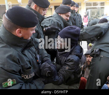 Gli ufficiali di polizia rompere un blocco stradale dei rifugiati e i dimostranti nella parte anteriore della stazione di polizia 33 a Berlino, Germania, 26 ottobre 2012. Essi hanno protestato l arresto dei profughi di fronte alla Porta di Brandeburgo il venerdì mattina. I rifugiati avevano protestato con uno sciopero della fame contro il tedesco aslyum politiche sulla Pariser Platz dal 24 Octerber 2012 dopo una marcia di protesta da Wu Foto Stock