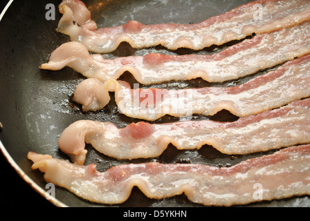 Friggere il bacon in una padella Foto Stock