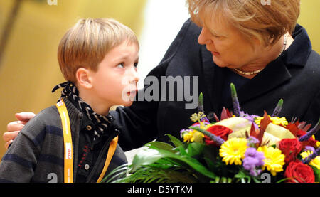 Il cancelliere tedesco Angela Merkel riceve i fiori dal piccolo Franz-Maria durante la riunione di partito dei democratici cristiani Meclemburgo-pomerania in Sternberg, Germania, 3 Novemner 2012. Foto: DANIEL REINHARDT Foto Stock