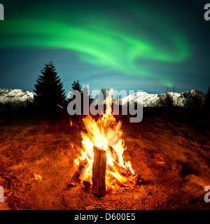 Guardando le luci del nord sat da un caldo fuoco di campo! Foto Stock