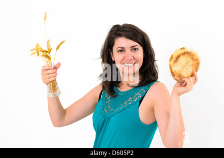 Giovane bella donna che mantiene i picchi di frumento e pane Foto Stock