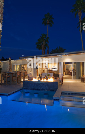 Vista posteriore della villa di lusso t tempo di notte con il fuoco acceso Foto Stock