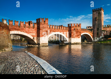 Vista del fiume Adige e medievale ponte in pietra del Ponte Scaligero di Verona, costruita nel XIV secolo nei pressi di Castelvecchio. L'Italia. Foto Stock