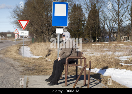 L uomo si trova a una fermata di autobus di campagna Foto Stock