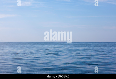 Un mare completamente vuoto, quasi pianeggiante e calmo nel canale di Bristol al largo della costa meridionale del Galles, orizzonte nella metà bassa, cielo azzurro e pigro, spazio per la copia Foto Stock