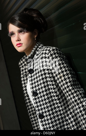 Una giovane e bella donna ragazza adolescente con anni sessanta lo stile dei capelli, vestiti e trucco, big ciglia, REGNO UNITO Foto Stock