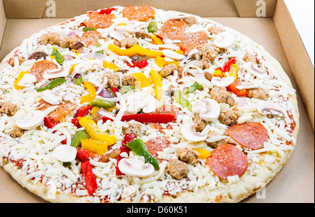 Foto orizzontale di pizza cruda, con un sacco di ingredienti freschi, in una scatola di cartone Foto Stock