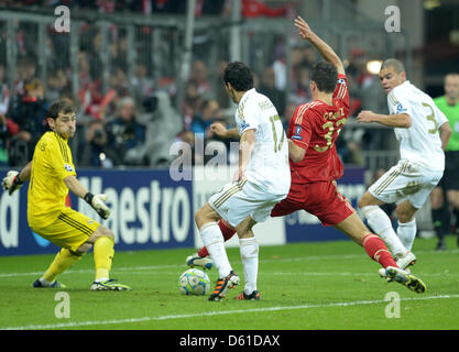 Monaco di Baviera è Mario Gomez (seconda R) punteggi 2-1 obiettivo accanto a Madrid il portiere Iker Casillas (L) e Alvaro Arbeloa (C) durante la Champions League semi finale prima gamba partita di calcio tra FC Bayern Monaco e Real Madrid nello stadio Allianz Arena di Monaco di Baviera, Germania, il 17 aprile 2012. Foto: Peter Kneffel dpa/lby +++(c) dpa - Bildfunk+++ Foto Stock