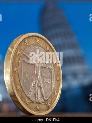 Illustrazione - un'immagine illustrata mostra un italiano 1 euro di moneta in piedi di fronte allo schermo di un computer sul quale un immagine della Torre Pendente di Pisa è visualizzato in Eichwalde, Germania, 17 aprile 2012. Foto: Tim Brakemeier Foto Stock