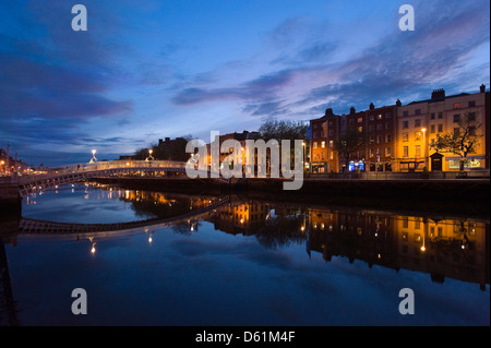 Vista orizzontale di Ha'penny Bridge aka Droichead na Leathphingine o Liffey bridge a Dublino al tramonto. Foto Stock