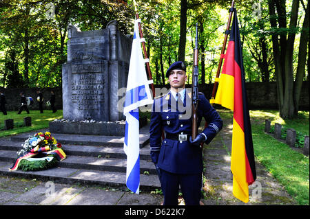 Un soldato tedesco si erige come israeliani e tedesco ufficiali militari stabiliscono una corona al cimitero ebraico nel distretto del Lago Weissensee in Berlino, Germania, 10 maggio 2012. I membri dell'esercito israeliano attualmente visitare l'Europa per commemorare le vittime dell'Olocausto. Foto: MAURIZIO GAMBARINI Foto Stock