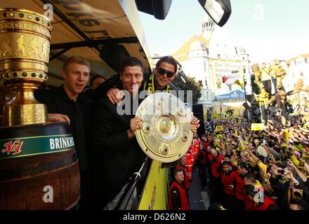 Robert Lewandowski e Roman Weidenfeller (R) della Bundesliga tedesca campioni del calcio Borussia Dortmund tenere il calcio tedesco campionato trofeo e il tedesco della DFB Cup Trofeo durante una sfilata per le strade di Dortmund, 13 maggio 2012. Il Borussia Dortmund ha vinto il tedesco della DFB Cup (DFB Pokal) finale contro il Bayern Monaco di Baviera a Berlino ieri. Foto: Ina Fassbender dpa/lnw Foto Stock