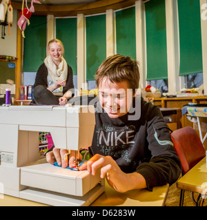 Ragazzo giovane imparare a cucire a scuola, Reykjavik, Islanda Foto Stock