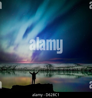 La donna la visualizzazione delle aurore boreali o luci del nord, Kleifarvatn, penisola di Reykjanes, Islanda Foto Stock