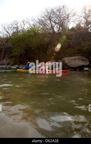 Guida africana prende turistico in canoa sulla ocean Foto Stock