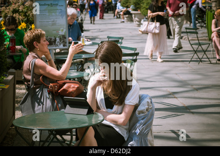 Un parco il visitatore con il suo tablet pc in Bryant Park di New York Foto Stock