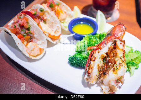 Chiusura del piatto di frutti di mare alla griglia - Coda di aragosta con gamberi tacos, burro e broccoli Foto Stock