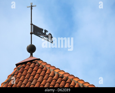 Vintage banderuola bird sul tetto rosso sopra il cielo blu. Parte vecchia di Tallinn, Estonia Foto Stock