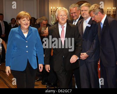 Il cancelliere tedesco Angela Merkel cammina accanto all ex Presidente delle Casse di Risparmio tedesche e Giro Associazione Heinrich Haasis (2-L) accanto all ex Presidente tedesco Christian Wulff (R) duirng l inaugurazione del nuovo presidente delle Casse di Risparmio tedesche e Giro Association (Deutscher Sparkassen- und Giroverband, DSGV), Georg Fahrenschon, Berlino, Germania, 22 maggio 2012. In th Foto Stock