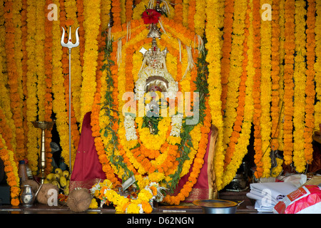 Una massa di fiori adorna la divinità Indù Durga a un tempio nel quartiere Khardunda di Mumbai, Maharastra, India Foto Stock