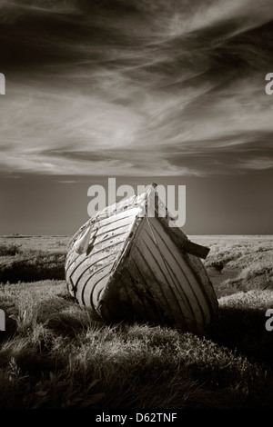 Lonely in legno antico la pesca in barca sul salmastra a Burnham Deepdale in Norfolk, Regno Unito Foto Stock