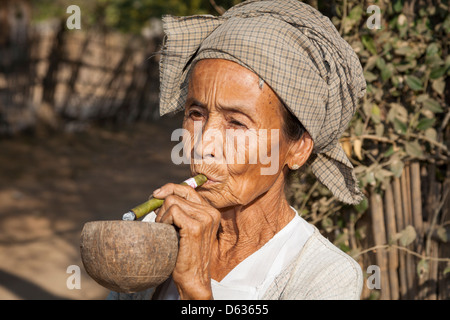 Vecchia donna fumare una cheroot, Minnanthu, Bagan, Myanmar (Birmania) Foto Stock