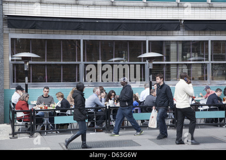 La gente mangia pranzo presso un cafè sul marciapiede, su Broadway da Union Square a Manhattan. Foto Stock