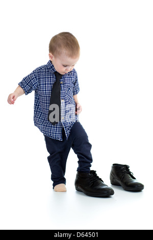 Little Boy cercando sul padre scarpe Foto Stock