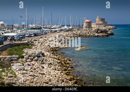 La fortezza medievale di San Nicola, antichi mulini a vento e il faro, in Mandraki Harbour, Rodi città nuova, Grecia. Foto Stock