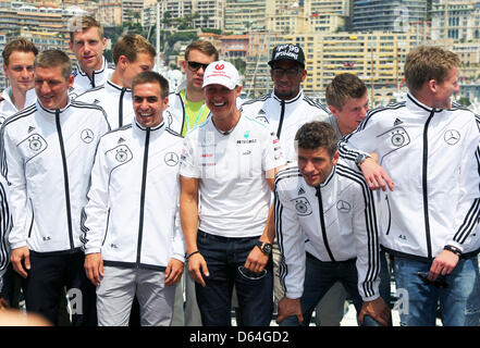 Nazionale tedesco di giocatori di calcio (L-R) Benedikt Hoewedes, Bastian SCHWEINSTEIGER, Per Mertesacker, Holger Badstuber, Philipp Lahm, Manuel Neuer, Jerome Boateng, Thomas Mueller, Toni Kroos e Andre Schuerrle e tedesco pilota di Formula Uno Michael Schumacher (C, tappo bianco) della Mercedes AMG visto prima della partenza alla gara di F1 Via di Monte Carlo, Monaco, 27 maggio 2012. Il Monaco di Formula Foto Stock