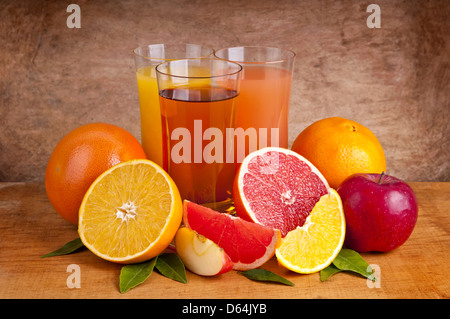 Succo di arancia, Apple e il succo di pompelmo e di frutti su un sfondo di legno Foto Stock