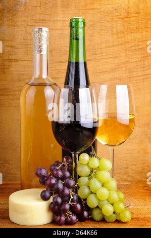 Ancora in vita con il vino bianco e rosso, uva e formaggio su un sfondo di legno Foto Stock