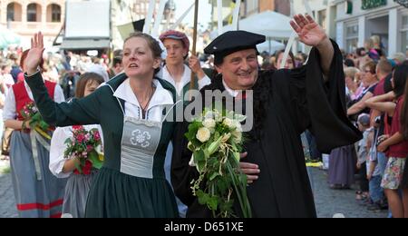 Questo anno di Lutero giovane Christiane Dalichow e Guenter Petermann wave durante il corteo presso la piazza del mercato a Wittenberg (Germania), 09 giugno 2012. Il corteo del XIX Wittenberg città festival 'Lutero di nozze" sta diventando sempre di più una folla estrattore. Secondo gli organizzatori di eventi il corteo era attenden da 40.000 visitatori oggi aleady. La festa si conclude il 10 giugno 201 Foto Stock