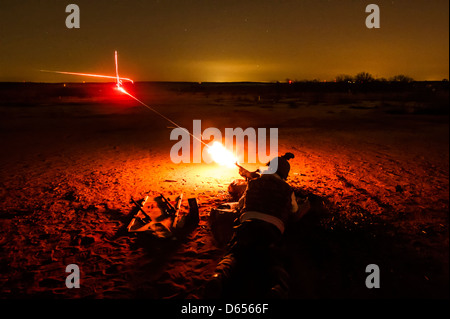 Striature chiare perforare il cielo notturno come noi Airman con il 628th forze di sicurezza incendi squadrone un M240B mitragliatrice durante l'addestramento alle armi Marzo 14, 201a Fort Jackson, SC. Foto Stock