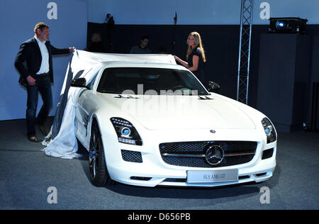 Due assistenti svelare la nuova Mercedes SLS AMG GT durante una presentazione della vettura in Affalterbach, Germania, 12 giugno 2012. AMG, una filiale della casa di Stoccarda auto azienda specializzata in alte prestazioni auto di lusso, andata in scena la presentazione in occasione della società del quarantacinquesimo anniversario. Foto: Jan-Philipp Strobel Foto Stock