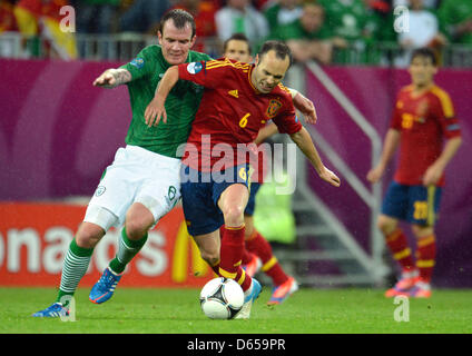 La Spagna di Andres Iniesta (C) e l'Irlanda di Glenn Whelan (L) si contendono la palla durante UEFA EURO 2012 gruppo C partita di calcio Spagna vs Repubblica di Irlanda a Arena Danzica Danzica, Polonia, 14 giugno 2012. Foto: Andreas Gebert dpa (si prega di fare riferimento ai capitoli 7 e 8 del http://dpaq.de/Ziovh per UEFA EURO 2012 Termini & Condizioni) +++(c) dpa - Bildfunk+++ Foto Stock