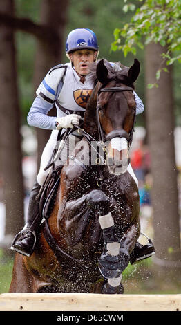 Il pilota statunitense Andrew Hoy salta il suo cavallo Laurino oltre un ostacolo di acqua durante la cross-country test in Luhmuehlen, Germania, 17 giugno 2012. Foto: Alexander Koerner Foto Stock