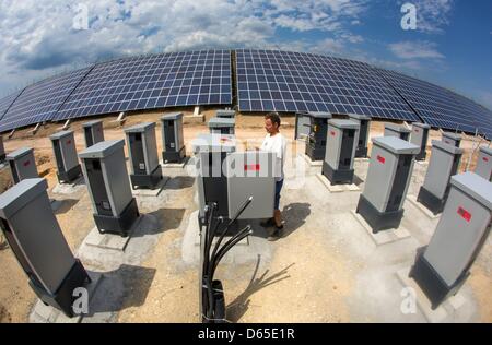 Un elettricista controlla il potenziale in entrata di un solare tabella dei grandi impianti fotovoltaici accanto alla autostrada Autobahn A4 vicino Kraftsdorf, Germania, 18 giugno 2012. Con un volume di investimento di 5,3 milioni di euro è previsto per generare 5,7 megawatt. Foto: MICHAEL REICHEL Foto Stock