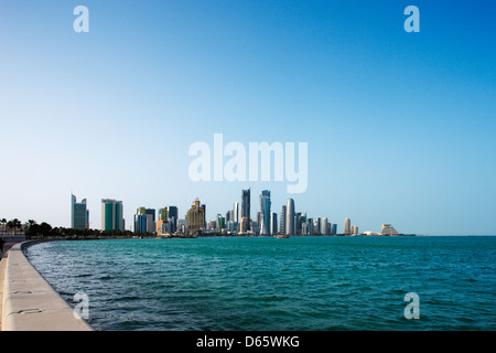 Doha Corniche in West Bay è un popolare luogo di esercizio per gli abitanti e i turisti. Un tradizionale dhow è ormeggiata nelle vicinanze Foto Stock