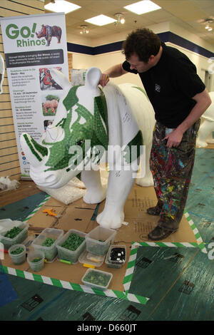 Southampton, Regno Unito. 12 Aprile 2013 - Rosie da tutte le informazioni su Art Ltd. lavorando sul suo Go! I rinoceronti scultura in Marlands Shopping Centre. Il finito di rinoceronti verrà visualizzato sulla scultura in tutta la città di questa estate da luglio a settembre prima di trasferirsi a Marwell Zoo in ottobre dove saranno vendute all'asta. Proventi saranno devoluti Marwell Wildlife, Wessex Heartbeat di alta 5 appello e la Rosa Associazione Strada del. Credito: Rob Arnold/Alamy Live News Foto Stock