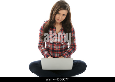 Young Woman seduto sul pavimento da solo utilizzando un computer portatile, lavorando da remoto a casa navigare su Internet, isolando da Coronavirus Foto Stock