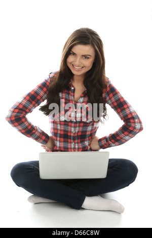 Young Woman seduto sul pavimento da solo utilizzando un computer portatile, lavorando da remoto a casa navigare su Internet, isolando da Coronavirus Foto Stock