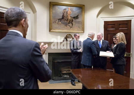 Il Presidente Usa Barack Obama applaude come Vice Presidente Joe Biden scuote le mani con il Direttore della CIA John Brennan seguendo il suo giuramento in occasione della cerimonia nella sala Roosevelt della Casa Bianca il 8 marzo, 2013 a Washington, DC. Brennan ha prestato giuramento come nuovo direttore della CIA. Foto Stock